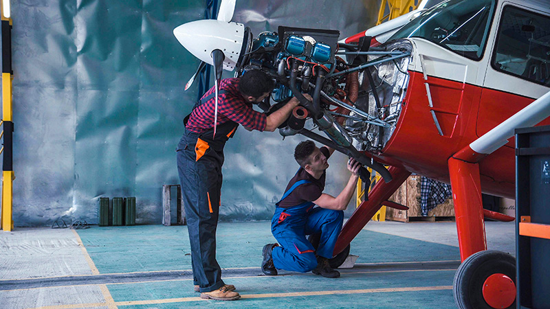 Airplane mechanics working on an insured plane